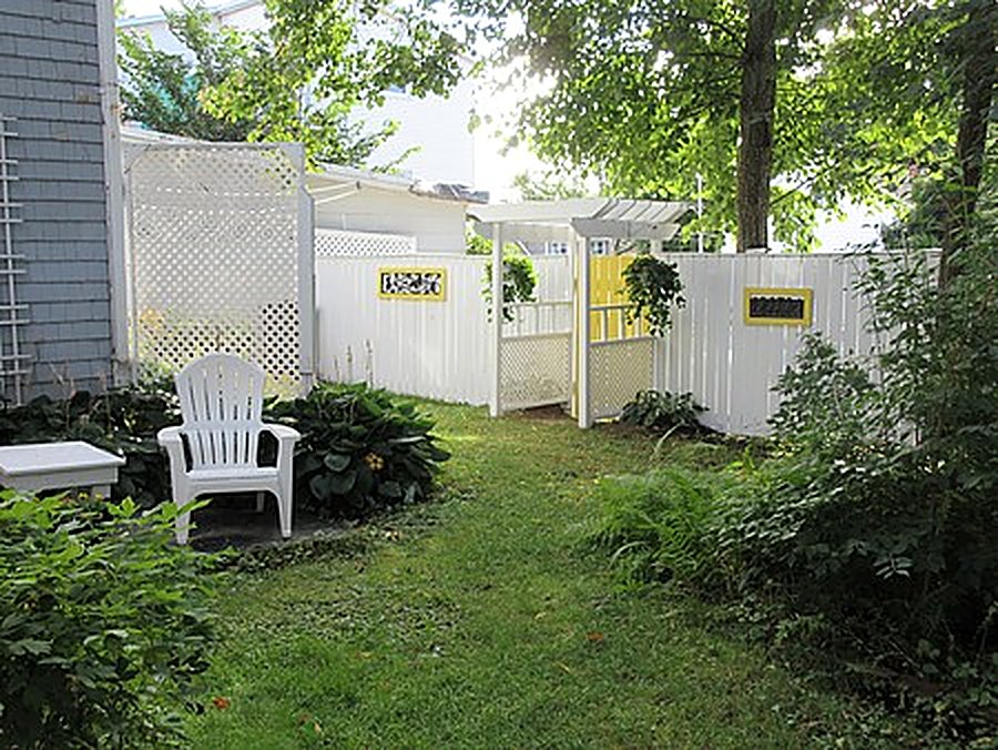 The inn's backyard garden with white fencing and lawn chairs