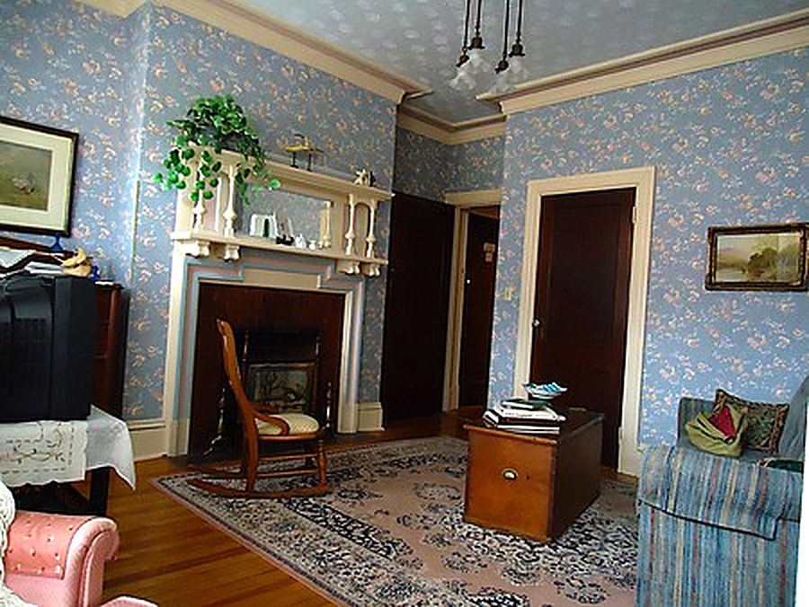 Guest living room with fireplace and period wallpaper