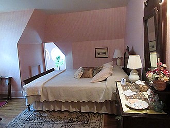 Guest bedroom with king bed under the sloped ceiling